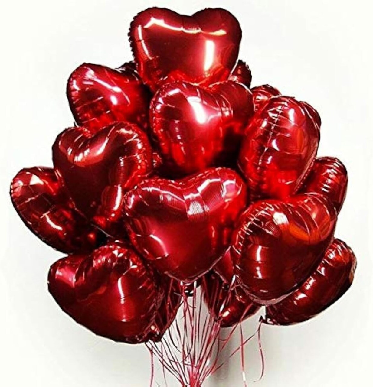 Bouquet of red heart-shaped balloons on a white background