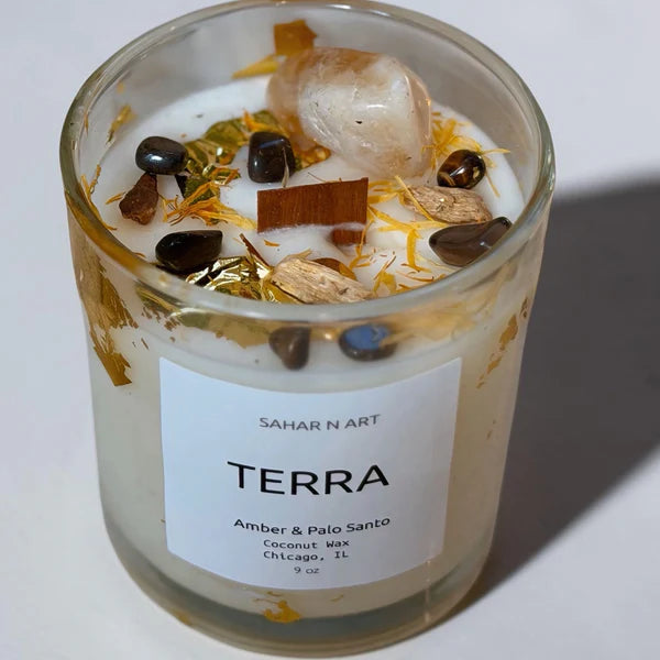 Candle in a glass jar with decorative elements and a label on a white background