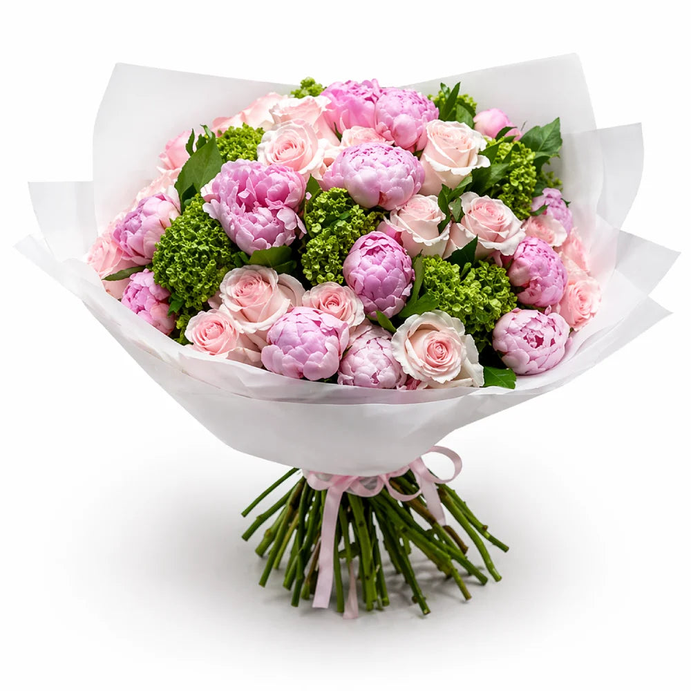 Bouquet of pink and green flowers wrapped in white paper on a white background