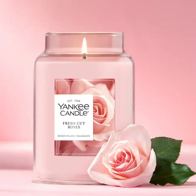 Yankee Candle Fresh Cut Roses candle with a pink rose on a pink background