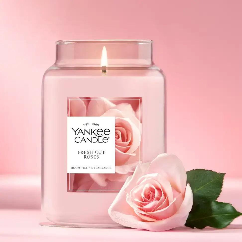 Yankee Candle Fresh Cut Roses candle with a pink rose on a pink background