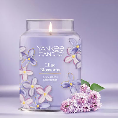 Yankee Candle Lilac Blossoms candle with floral design on a light purple background