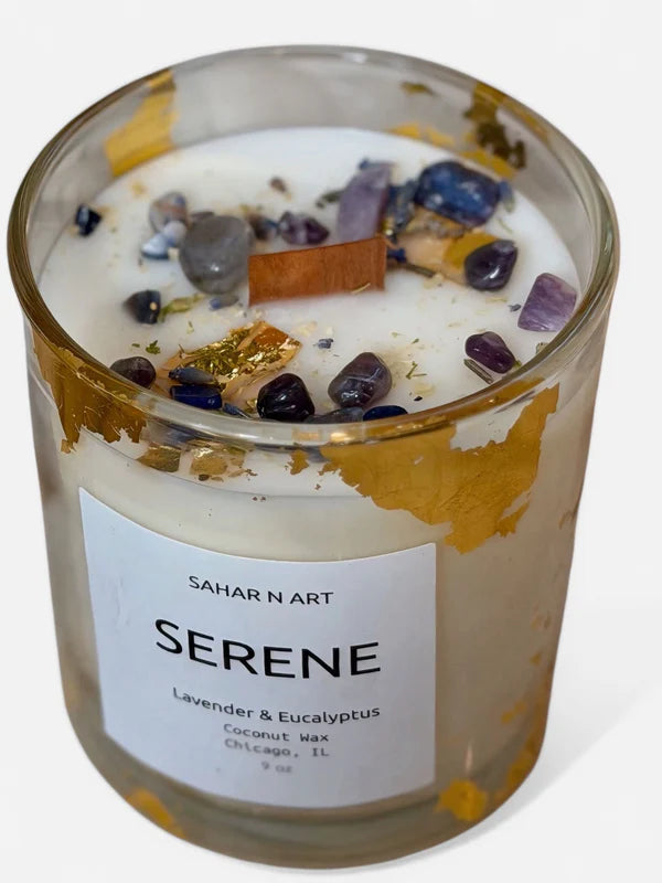 Scented candle with decorative stones and a 'Sahar N' Art' label on a white background